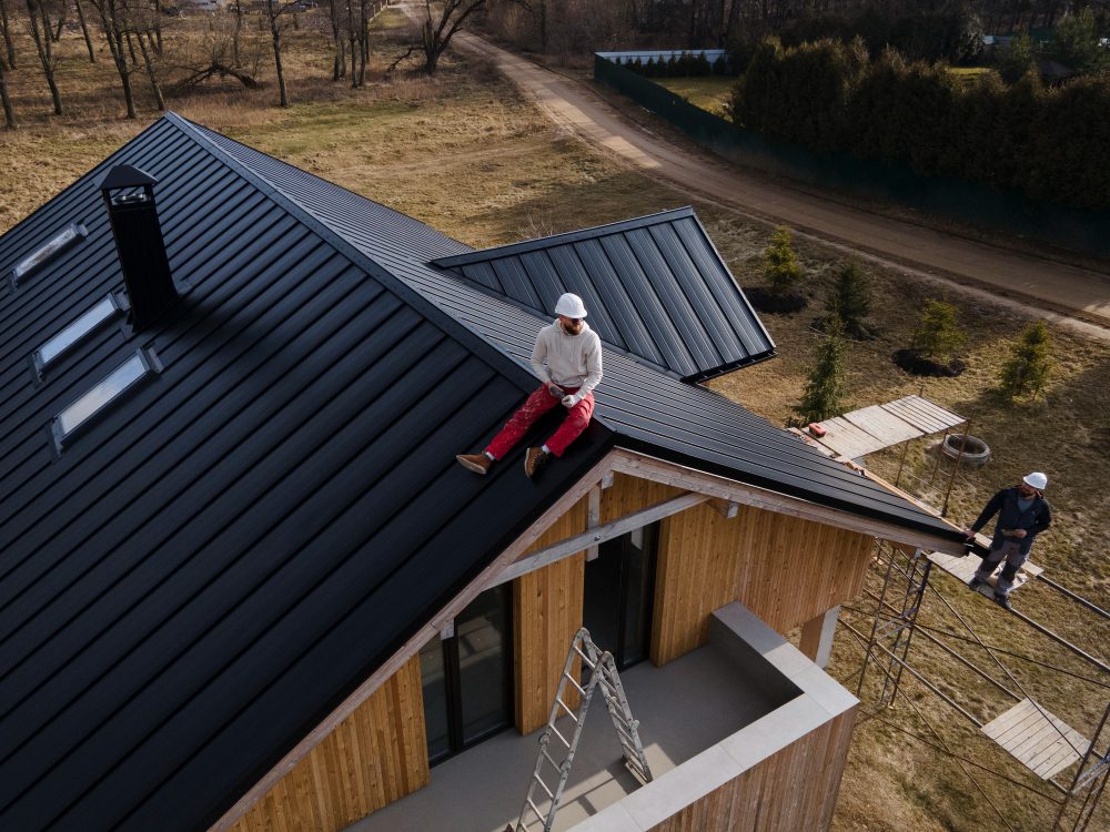 long-shot-man-with-helmet-sitting-roof.jpg